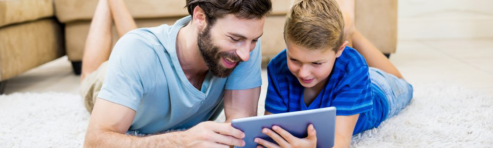 Vater spielt mit Sohn am Tablet